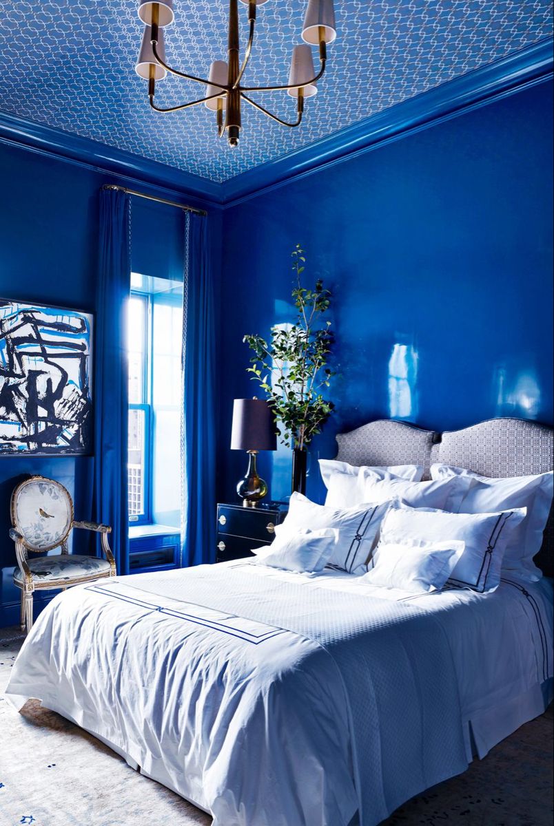 Elegant bedroom with blue walls, white bedding, and decorative elements.