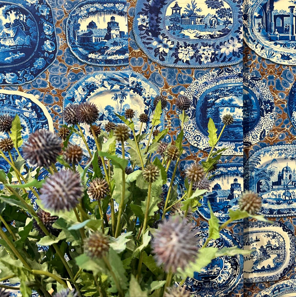Collage of blue and white patterned fabric with green plants and brown flowers.