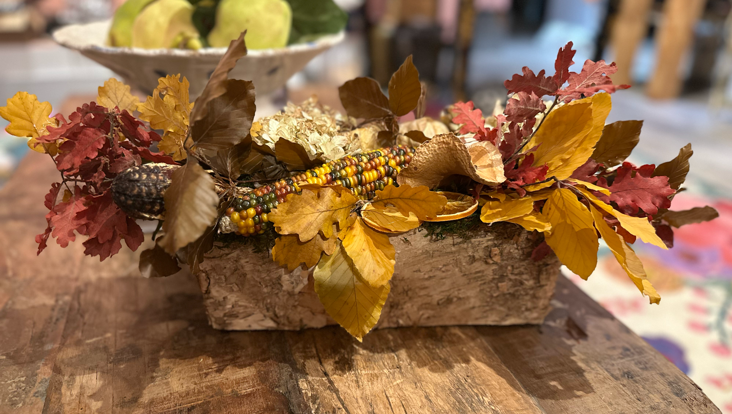 Custom Fall Dried Arr. centerpiece with Indian corn and preserved autumn leaves in birch container