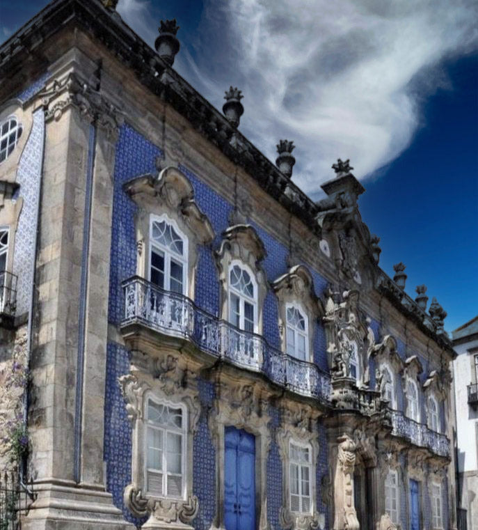 Decorative building facade with blue doors and intricate details against a blue sky.