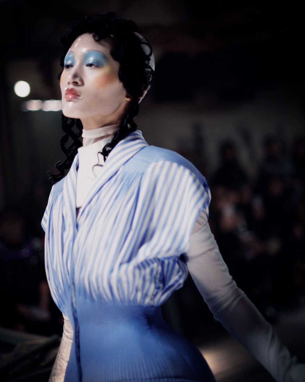 Person wearing a blue and white outfit on a dark background